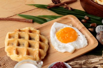 Sweet waffles and fresh milk with jam and egg heart.