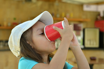 Little girl drink from cup