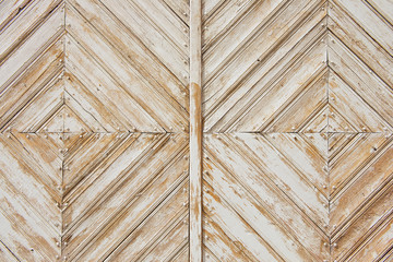 Rhomb pattern of the old weathered white-painted wooden gate.