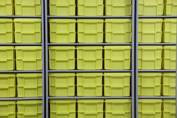 Large pile of yellow plastic closed tool boxes