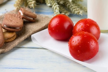 Three washed cherry tomatoes on paper sheet