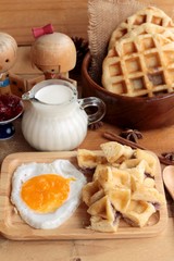 Sweet waffles and fresh milk with jam and egg heart.