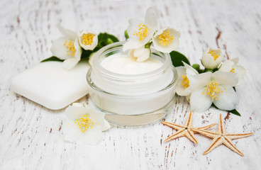 face and body cream moisturizers with jasmine flowers on white w