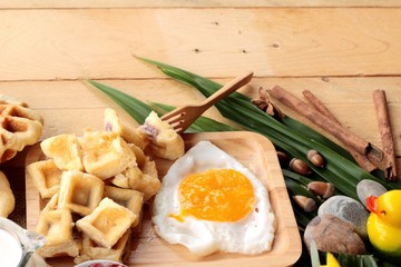 Sweet waffles and fresh milk with jam and egg heart.