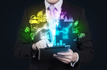 Businessman editing the annual report charts. Working on a tablet computer. Hologram charts as a...