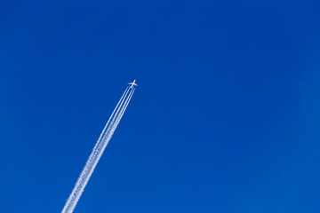 Aereo con scia bianca su sfondo azzurro in montagna