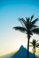 Fototapeta na wymiar Sunset in Rio de Janeiro Ipanema Beach Brazil with Two Brothers Dois Irmaos Mountain and palm tree silhouette