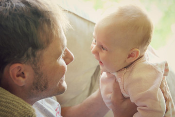 Young Father Playing with Newborn Baby Girl