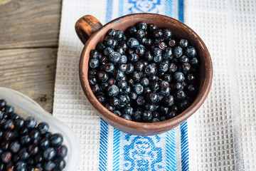 Fresh blueberries in a clay cup on a gray wood background