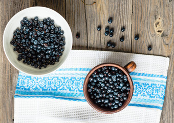 Fresh blueberries in a clay cup and a white plate, raw