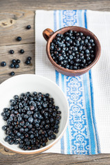 Fresh blueberries in a clay cup and a white plate, raw