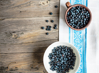 Fototapeta na wymiar Fresh blueberries in a clay cup and a white plate, raw