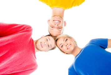 Happy students in colorful clothing standing together touching heads