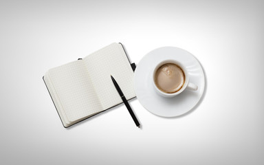 Coffee cup with note book on table