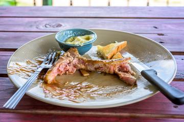 Empty steak dish after food on the table