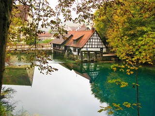 Fototapeta premium Water mill at Blautopf in autumn, Blaubeuren, Germany