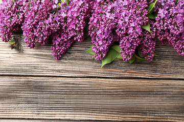 Purple lilac flowers on brown wooden background