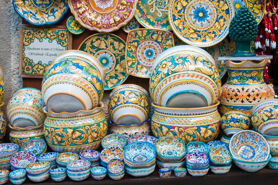 Various decorated ceramic dishes, vases, and bowls for sale outside a souvenir shop in Erice, Sicily