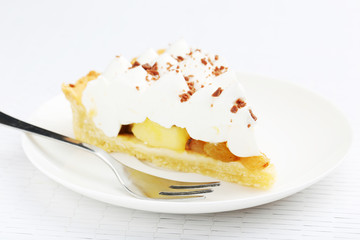 Apple cake with meringue on white plate