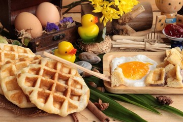 Sweet waffles and fresh milk with jam and egg heart.