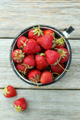 Strawberries berry in cup on grey wooden background
