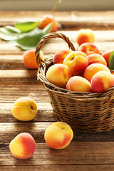 Fototapeta na wymiar Fresh apricots in basket on a brown wooden background