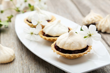 French meringue cookies in tartlet on plate on grey wooden backg