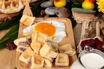 Sweet waffles and fresh milk with jam and egg heart.