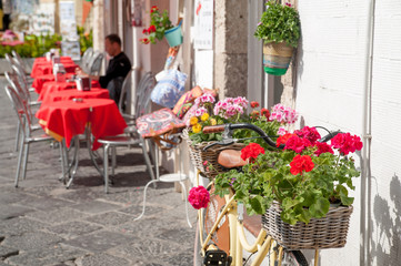 Fototapeta na wymiar Tourist bike with flowered wicker basket along the streets of Ortigia, the old Syracuse
