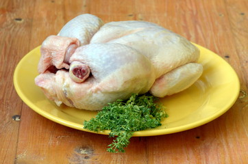 Raw chicken with a bunch of basil.