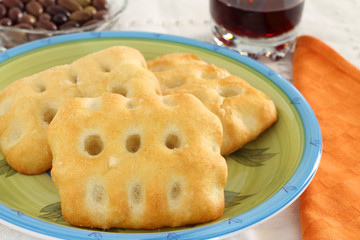 Focaccia with background of black olives and glass of wine
