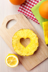 Pineapple slice with cut in shape of heart on table close up