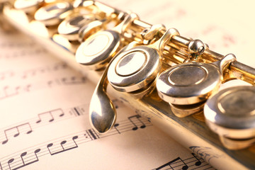 Silver flute on music notes background