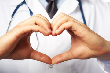 Doctor's hands making heart shape close up