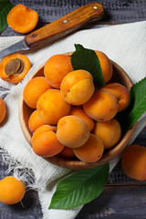 Fresh ripe apricots in wooden bowl