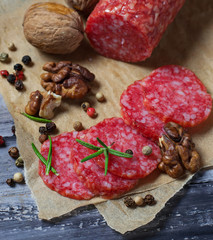 Sliced salami with walnuts and rosemary
