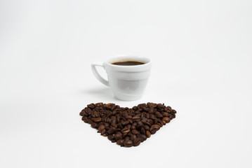 Cup coffee on a Heart shape made from coffee on white background