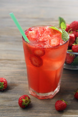 Glasses of strawberry juice with berries on table close up