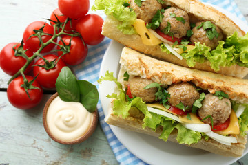 Homemade Spicy Meatball Sub Sandwich on plate, on wooden table background