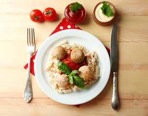 Pasta with meatballs on plate, on wooden  table background