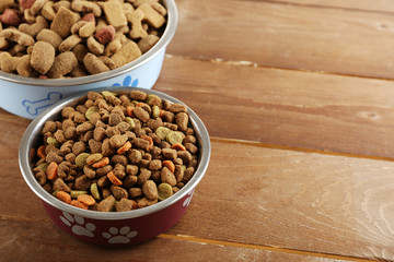 Dog food in bowls on wooden table