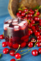 Glass of fresh juice with cherries on wooden table close up