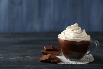 Cup of coffee with cream on color wooden background