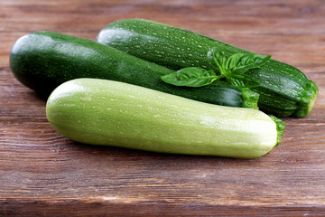 Fresh zucchini with squash and basil on wooden background