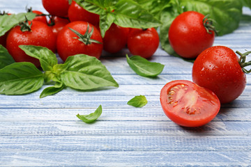 Fresh tomatoes with basil on wooden table close up