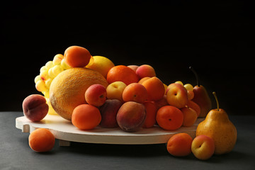 Heap of fresh fruits on dark background