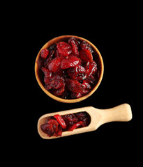 Dry dogwood fruits in wooden bowl, isolated on black