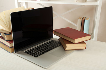 Laptop with books on table close up