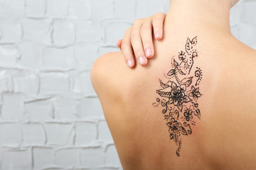 Back painted with henna - Mehendi on grey wall background