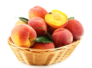 Ripe peaches in basket isolated on white